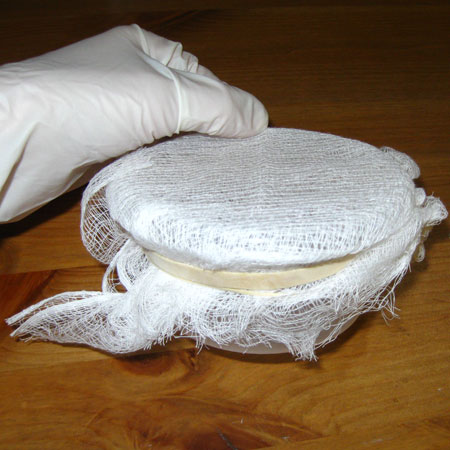 Use a rubber band to hold some cheesecloth onto a microwave safe container.